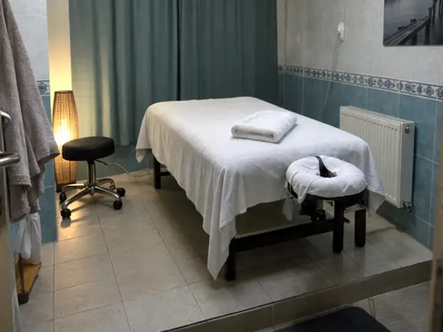 Mavi perdeli odada masaj masası ve tabure — Emin Sinan, Masaj Salonun